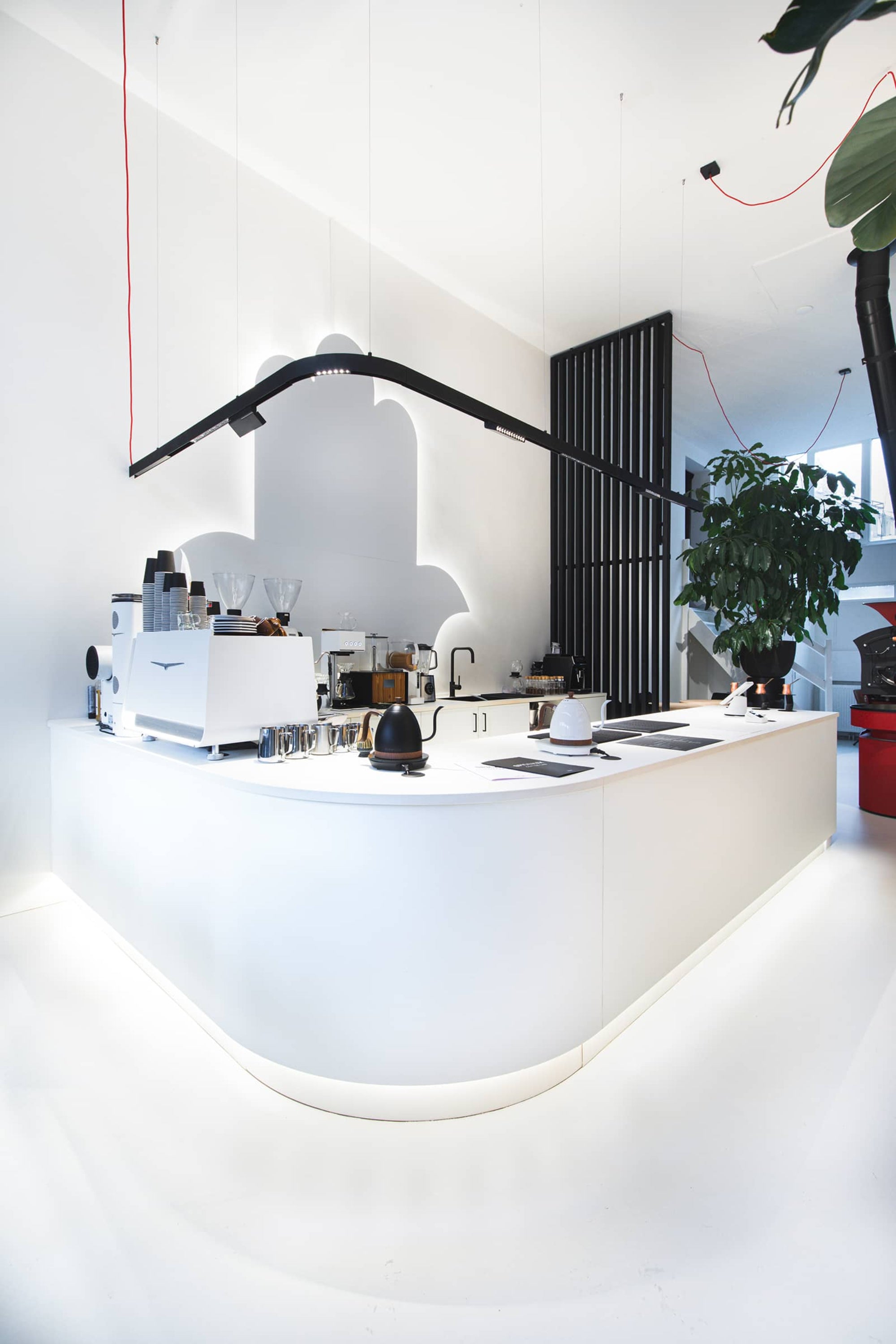 Moderne inrichting koffiebar met wit maatwerk koffiebar interieur en strakke toonbank koffiebar met espressomachine.