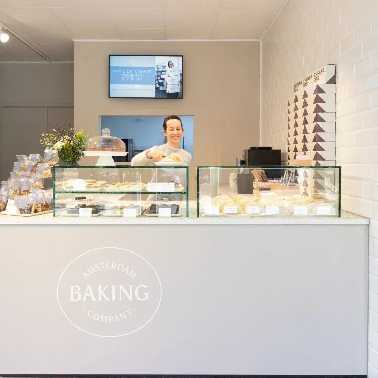 winkelinrichting op maat met grijze bakkerijtoonbank, glazen vitrines met brood en patisserie productpresentatie en modern bakkerij winkelinterieur
