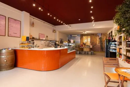 winkelinrichting op maat met oranje betegelde toonbank, glazen vitrine, productpresentatie en modern speciaalzaak winkelinterieur