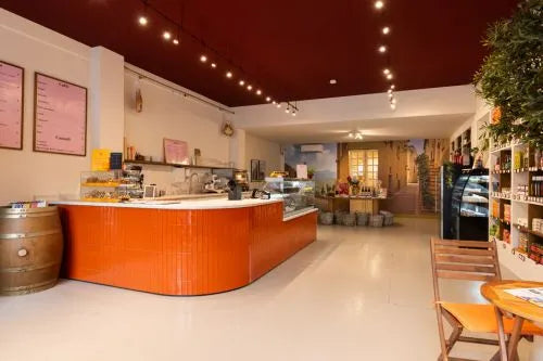 winkelinrichting op maat met oranje betegelde toonbank, glazen vitrine, productpresentatie en modern speciaalzaak winkelinterieur