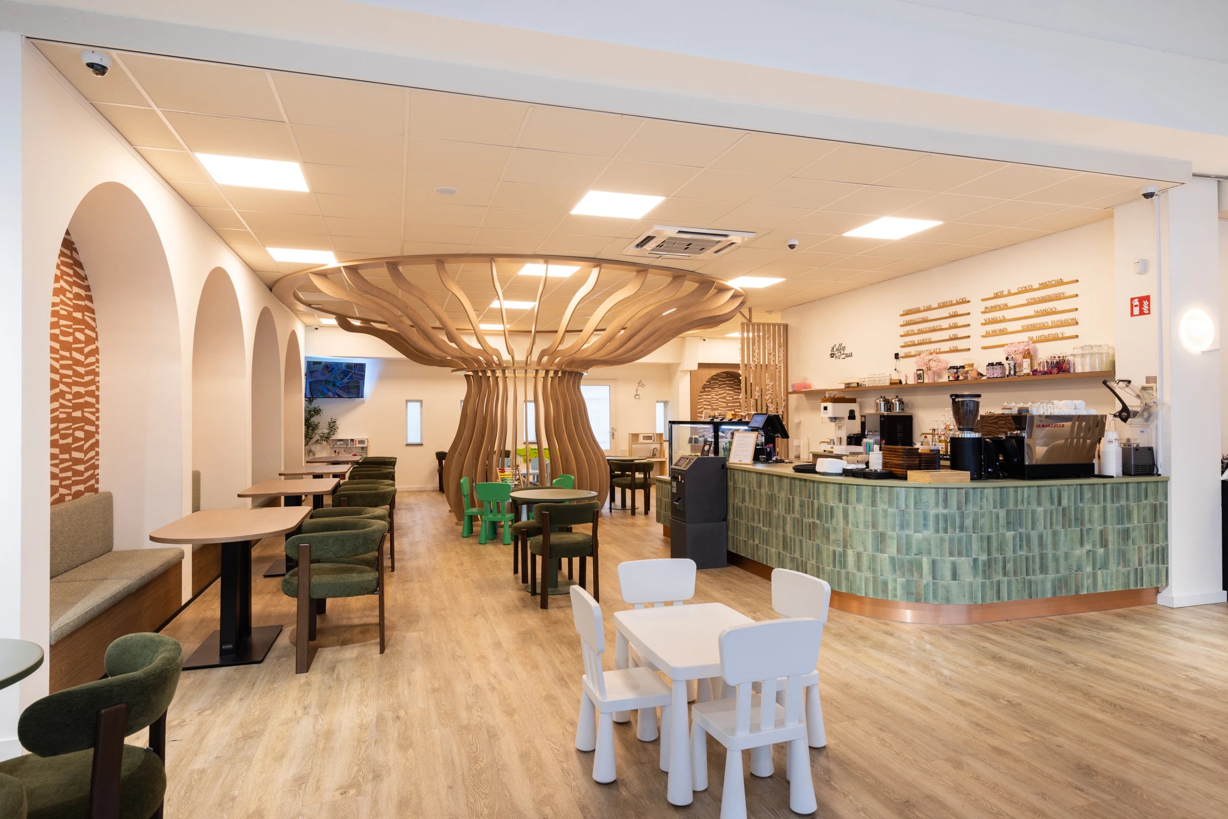 Cafe groene toonbank met koffiezet apparaat mooie divider in het midden van de ruimte, met witte bogen in de muur