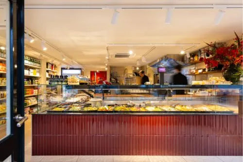 winkelinrichting op maat met donkerrode betegelde toonbank, lange glazen vitrine met versproductpresentatie en modern delicatessenwinkel interieur
