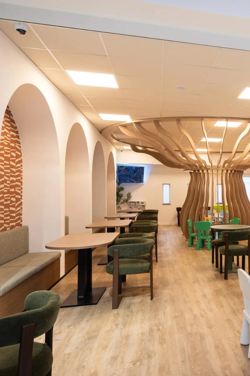 horeca winkel interieur groene stoelen witte bogen in de muur mooi design in het midden van de ruimte