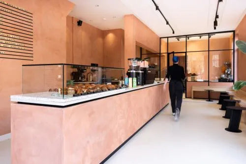 winkelinrichting op maat met lange roze toonbank, glazen vitrine en productpresentatie in modern winkelinterieur