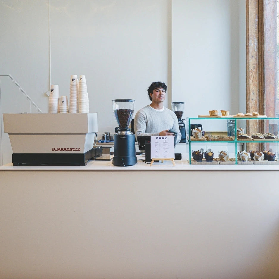 winkelinrichting op maat met minimalistische witte toonbank, glazen vitrine voor gebakpresentatie en modern koffiebar winkelinterieur