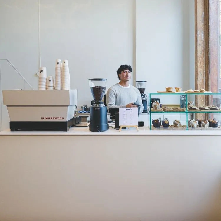 winkelinrichting op maat met minimalistische witte toonbank, glazen vitrine voor gebakpresentatie en modern koffiebar winkelinterieur