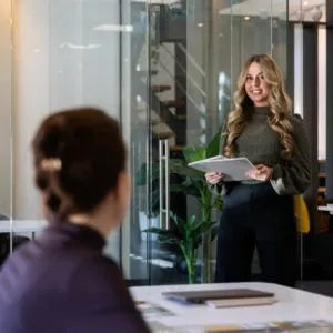 winkelinrichting op maat met moderne kantoorruimte, glazen wanden en medewerker met tablet in professioneel interieur