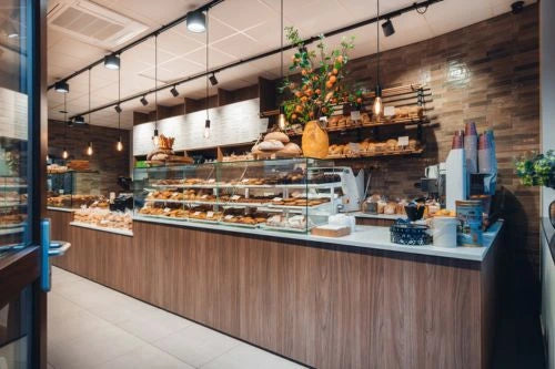 winkelinrichting op maat met lange houten bakkerijtoonbank, glazen vitrines en broodproductpresentatie in modern bakkerij winkelinterieur