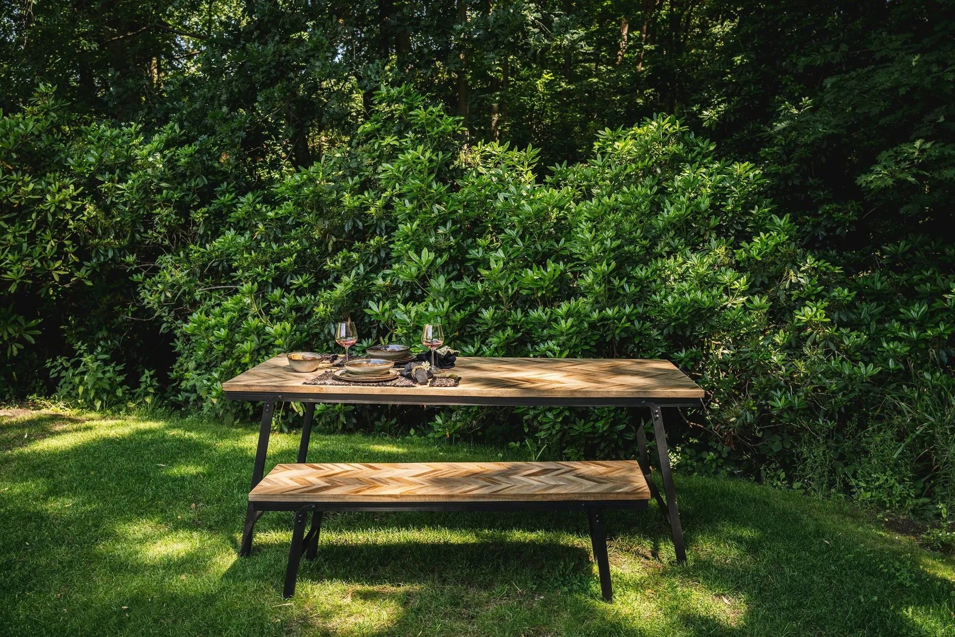 Bazar Bizar The Herringbone Bank ( Natuurlijk - 150) in de tuin met de bijbehorende tafel
