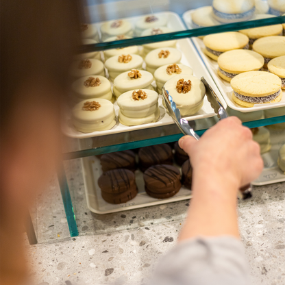 Glasvitrine op toonbank gevuld met patisserie producten